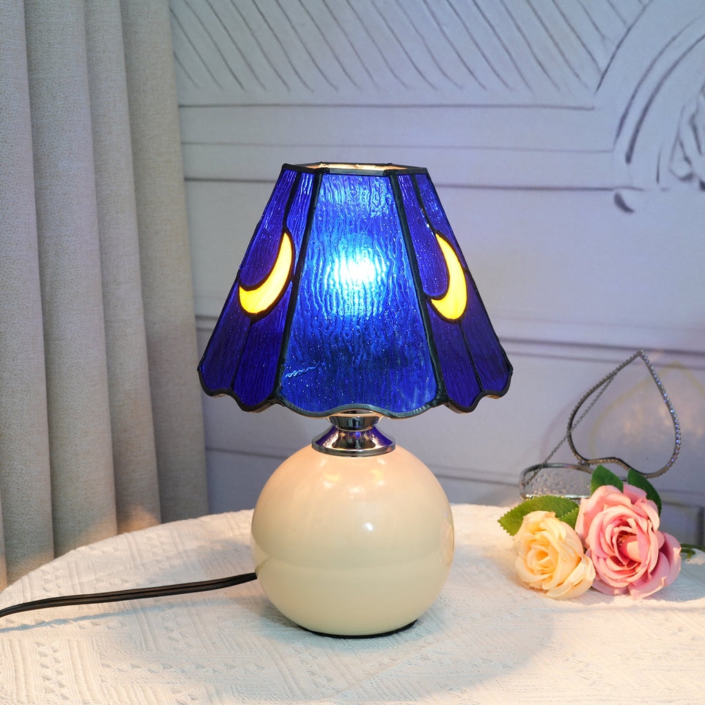 Blue stained glass bedside lamp with moons on a cream base