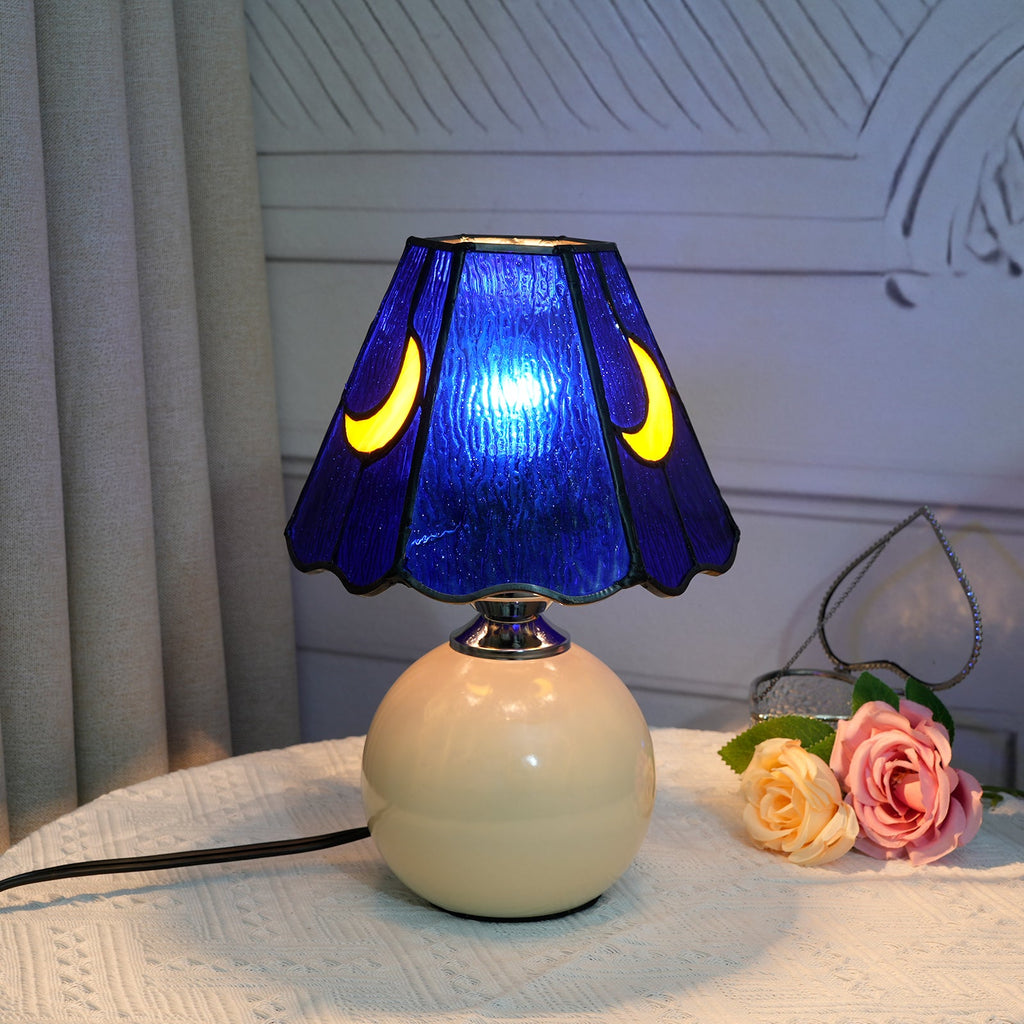 Blue stained glass bedside lamp with moons on a cream base