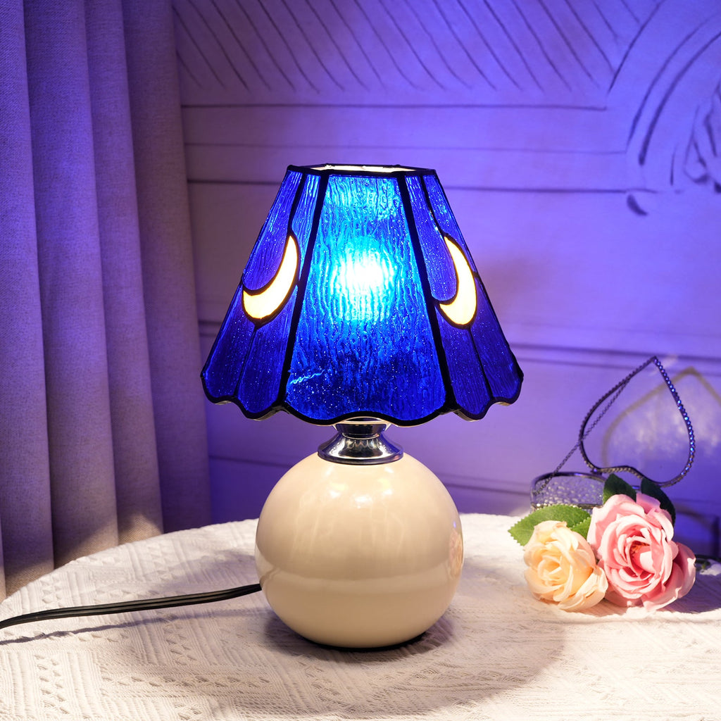 Blue stained glass bedside lamp with moons on a cream base