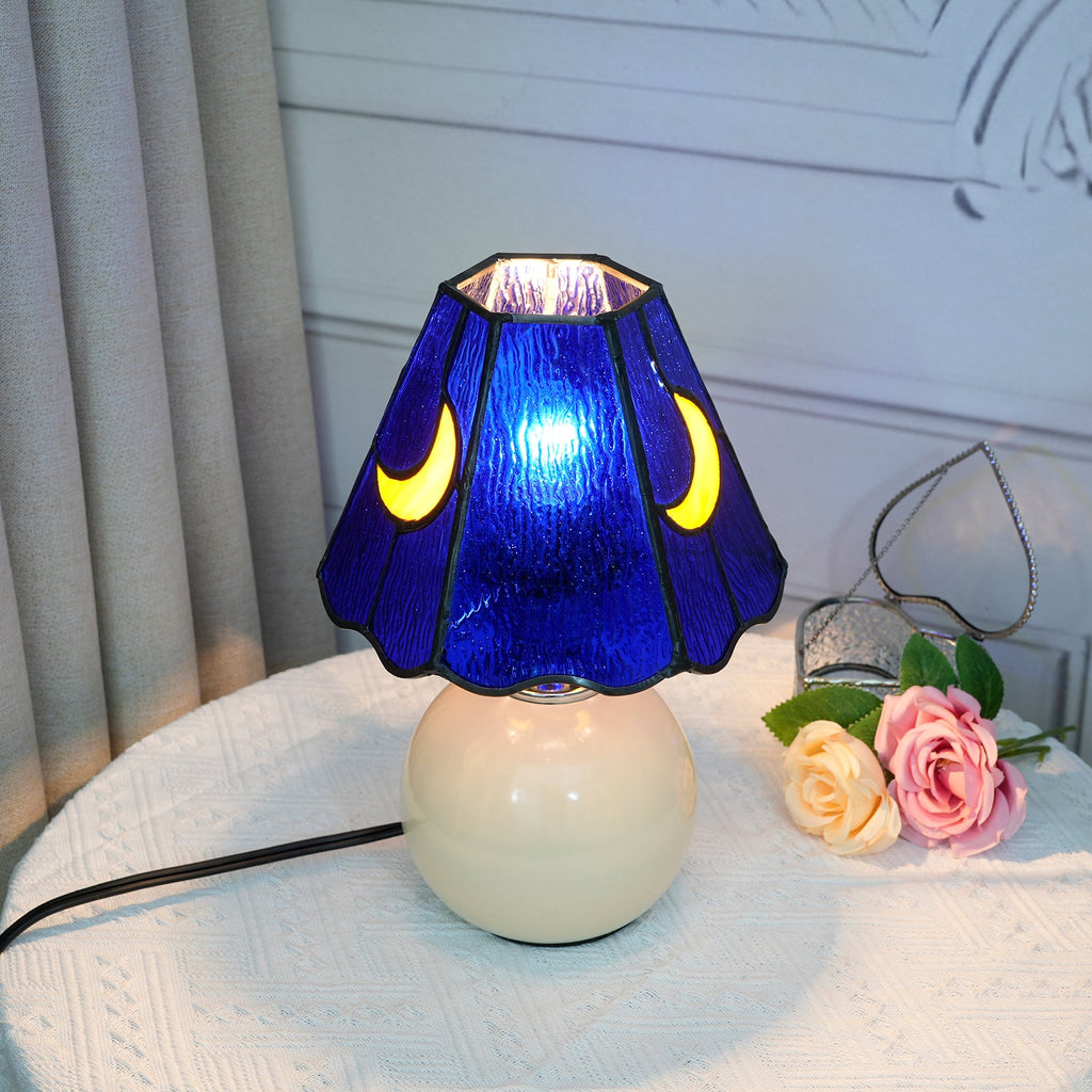 Blue stained glass bedside lamp with moons on a cream base
