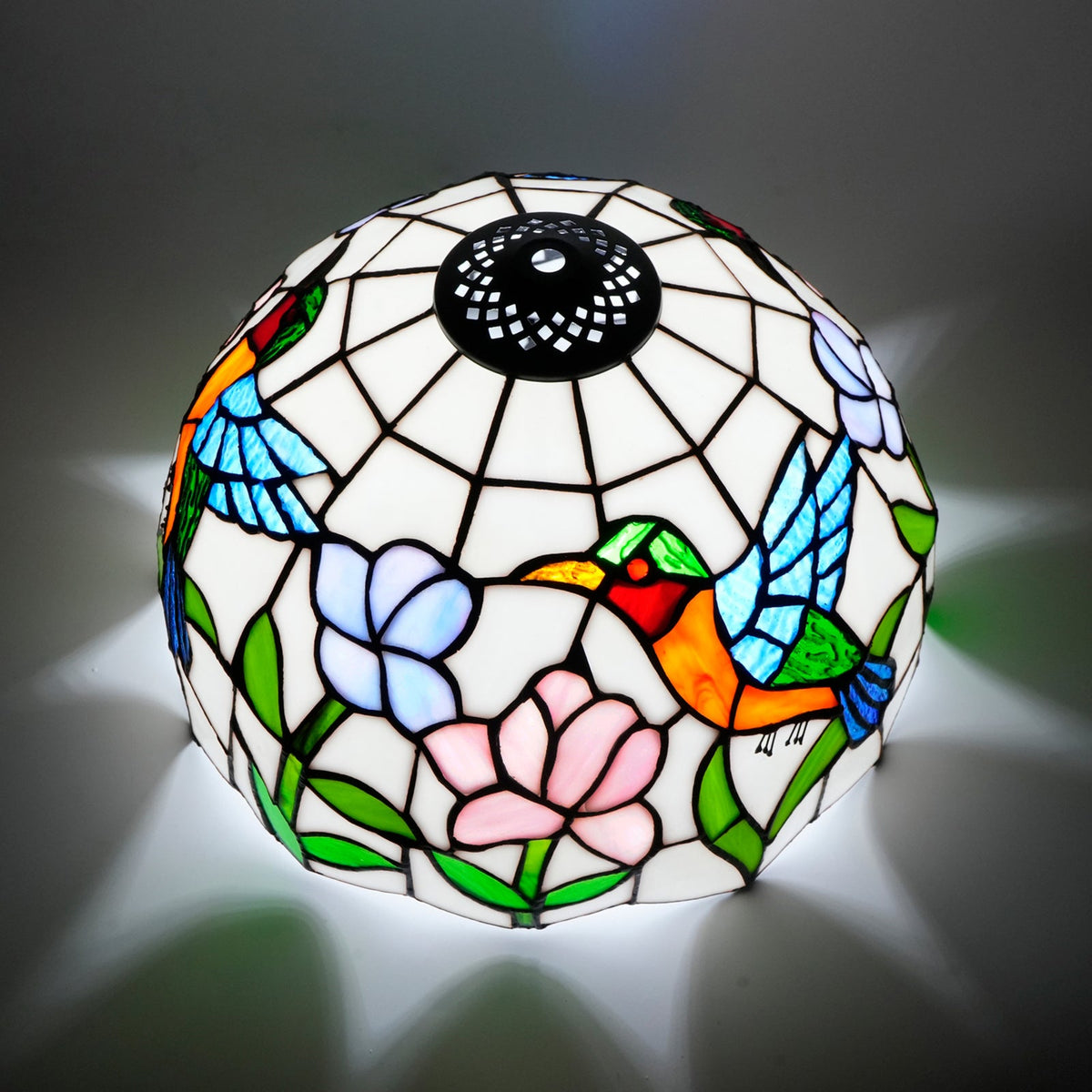Tiffany-style lampshade in stained glass with a hummingbird and flower design.