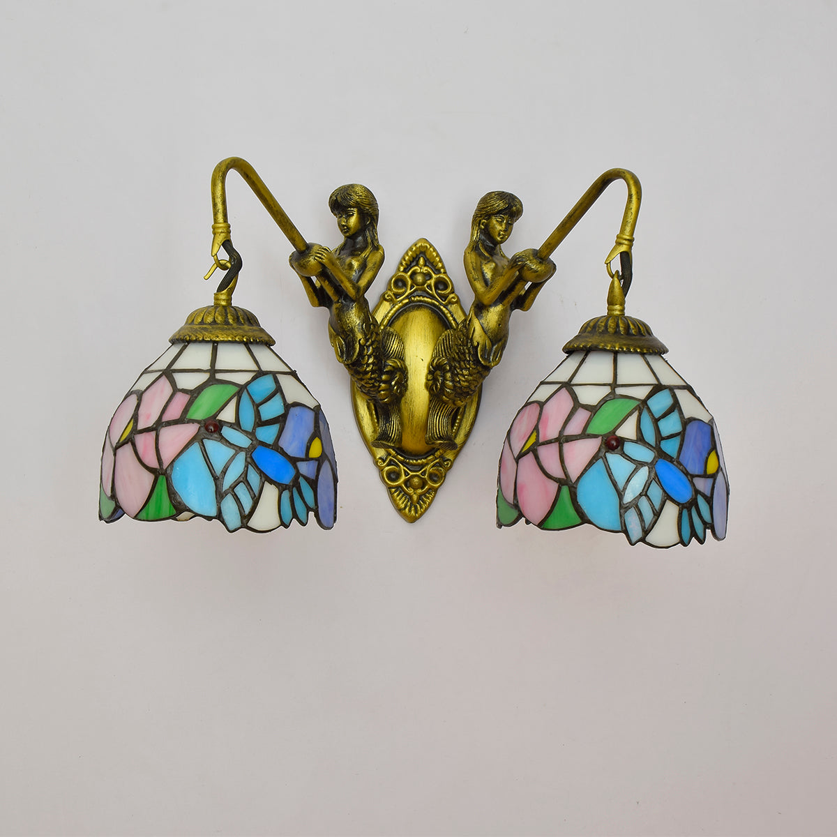 Tiffany-style wall sconce in stained glass and brass, featuring mermaids.